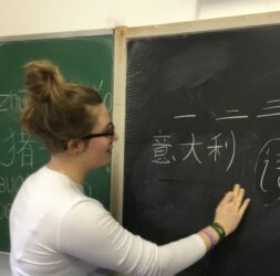 Studentessa alla lavagna che scrive in cinese